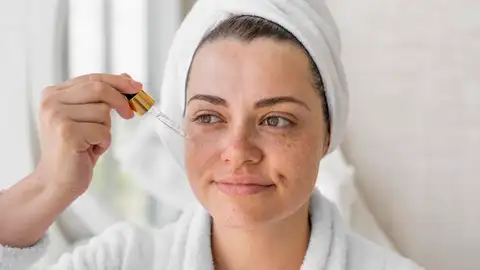 Mujer usando un cosmético Mujer usando un cosmético