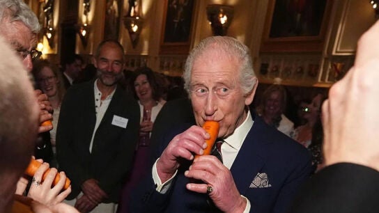 El rey Carlos III toca una flauta de zanahoria