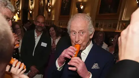 El rey Carlos III toca una flauta de zanahoria El rey Carlos III toca una flauta de zanahoria