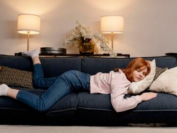 Una mujer descansa en el sof&aacute;