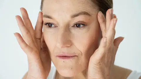 Mujer estirándose la piel del rostro Mujer estirándose la piel del rostro