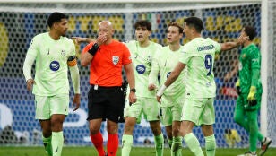 Los jugadores del barcelona protestan ante Szymon Marciniak