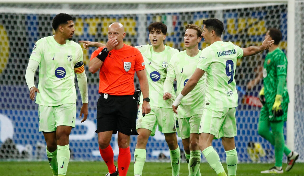 Los jugadores del barcelona protestan ante Szymon Marciniak