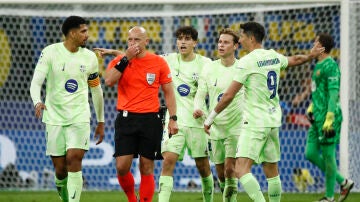 Los jugadores del barcelona protestan ante Szymon Marciniak