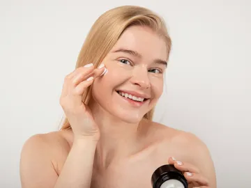 Mujer aplicándose cosmético Mujer aplicándose cosmético