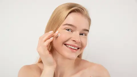 Mujer aplicándose cosmético Mujer aplicándose cosmético