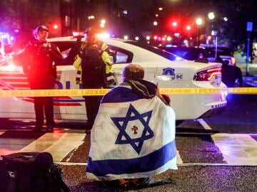 Un hombre con la bandera de Israel en el lugar de los disparos