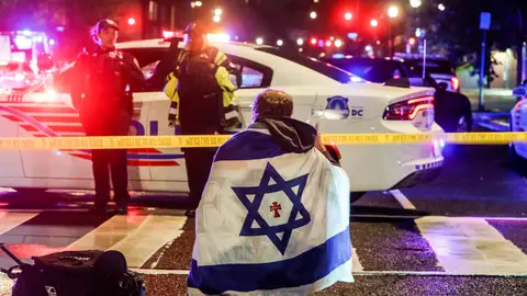 Un hombre con la bandera de Israel en el lugar de los disparos Un hombre con la bandera de Israel en el lugar de los disparos