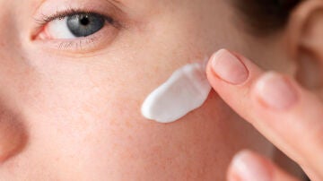 Mujer poniéndose crema solar en el rostro