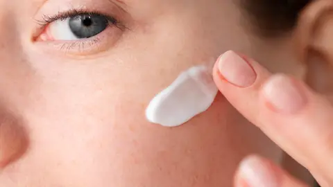 Mujer poniéndose crema solar en el rostro Mujer poniéndose crema solar en el rostro