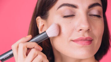 Mujer aplicándose colorete