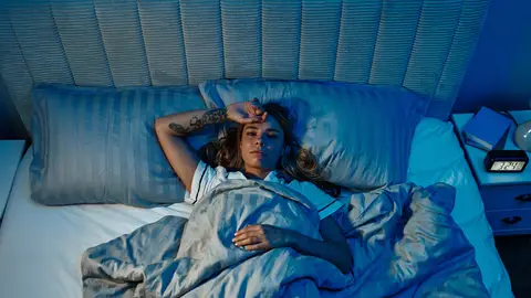 Mujer despierta en la cama Mujer despierta en la cama