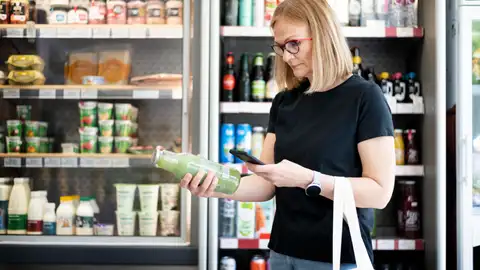 Una mujer analiza con una app la etiqueta de un producto del supermercado Una mujer analiza con una app la etiqueta de un producto del supermercado