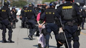 Autoridades deteniendo a una protestante
