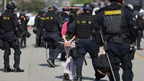 Autoridades deteniendo a una protestante Autoridades deteniendo a una protestante