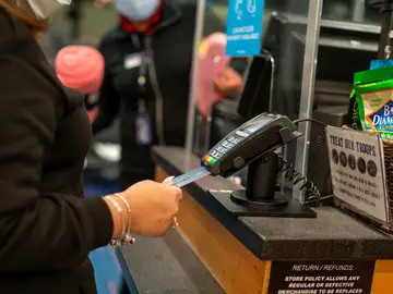 Una persona usando una tarjeta de crédito Una persona usando una tarjeta de crédito