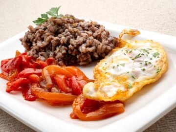 Arroz con morcilla, huevos fritos y pimientos rojos
