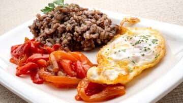Arroz con morcilla, huevos fritos y pimientos rojos