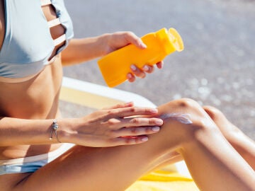 Mujer poni&eacute;ndose crema solar