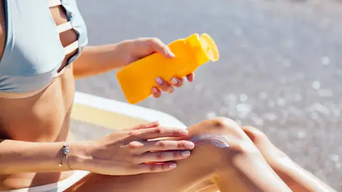 Mujer poniéndose crema solar Mujer poniéndose crema solar