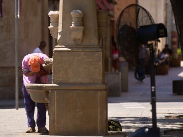 Un hombre se refresca en una fuente este sábado en Lleida