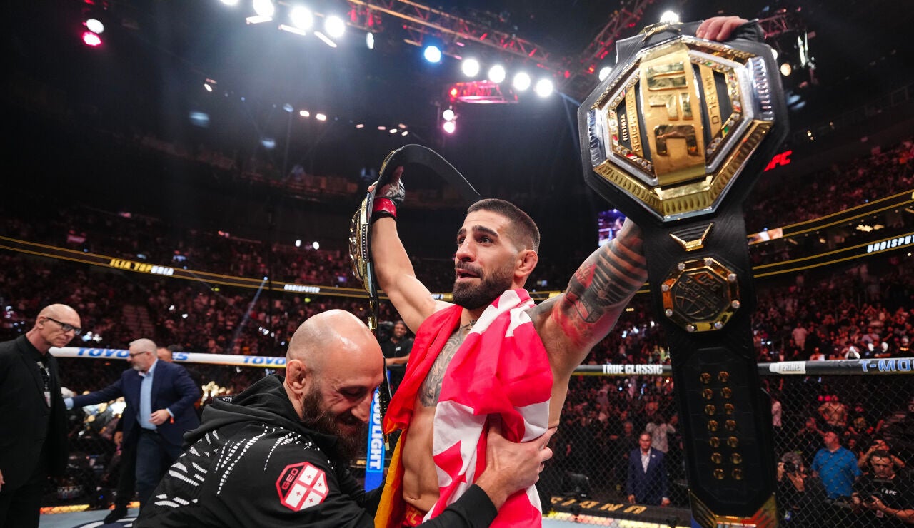 Ilia Topuria levanta los brazos con sus dos cinturones de la UFC