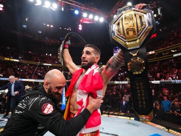 Ilia Topuria levanta los brazos con sus dos cinturones de la UFC