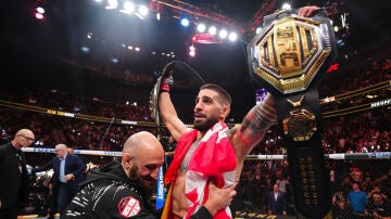 Ilia Topuria levanta los brazos con sus dos cinturones de la UFC