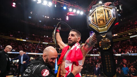 Ilia Topuria levanta los brazos con sus dos cinturones de la UFC