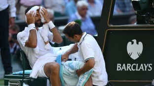 Novak Djokovic es atendido durante las semifinales de Wimbledon