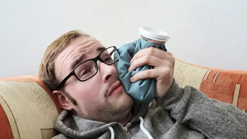 Hombre con una bolsa de hielo para los golpes Hombre con una bolsa de hielo para los golpes