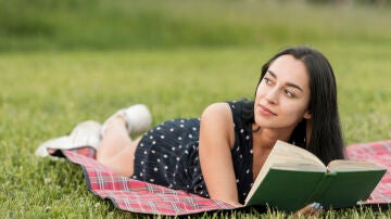 Chica leyendo tumbada en el césped
