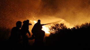 Imagen de los bomberos de Grecia haciendo frente a las llamas y el viento 
