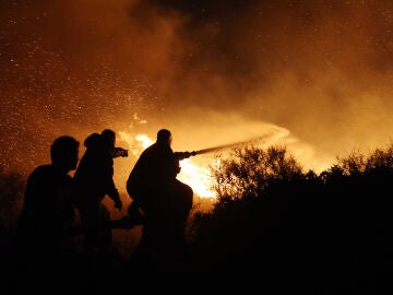 Imagen de los bomberos de Grecia haciendo frente a las llamas y el viento 