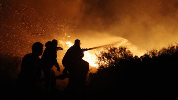 Imagen de los bomberos de Grecia haciendo frente a las llamas y el viento 