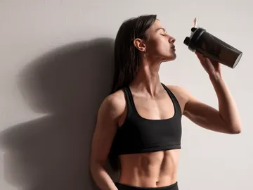 Mujer tomándose un batido de proteina Mujer tomándose un batido de proteina