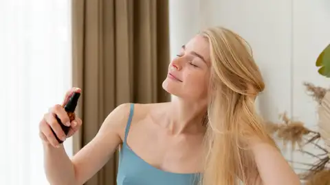 Mujer echándose una bruma perfumada Mujer echándose una bruma perfumada