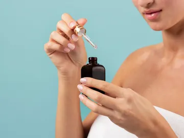 Mujer con un cosmético en la mano Mujer con un cosmético en la mano