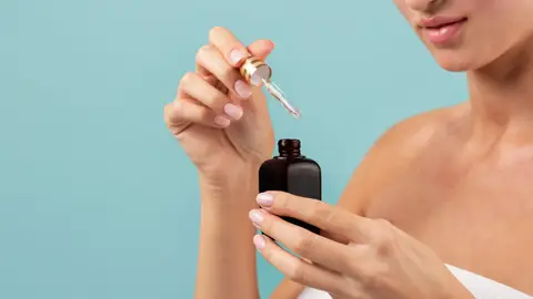 Mujer con un cosmético en la mano Mujer con un cosmético en la mano