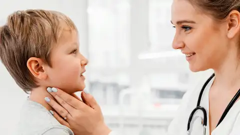 Revisión de la pediatra de los ganglios en el cuello de un niño Revisión de la pediatra de los ganglios en el cuello de un niño