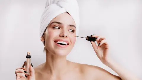 Mujer aplicándose un cosmético Mujer aplicándose un cosmético