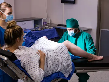 Una mujer y el equipo médico en el momento del parto Una mujer y el equipo médico en el momento del parto