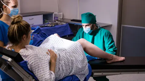 Una mujer y el equipo médico en el momento del parto Una mujer y el equipo médico en el momento del parto