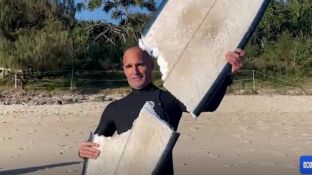 Imagen del surfista con la tabla destrozada