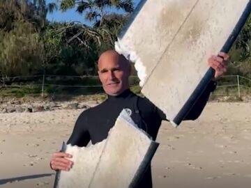 Imagen del surfista con la tabla destrozada