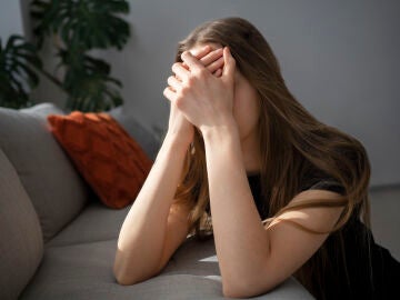 Una mujer tap&aacute;ndose la cara por ansiedad