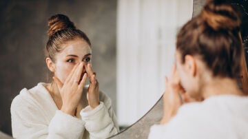Mujer aplicándose cosmético en la cara