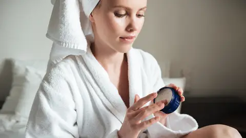 Mujer con un cosmético en la mano Mujer con un cosmético en la mano