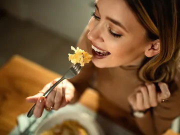 Una mujer disfrutando de la comida Una mujer disfrutando de la comida