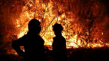 Bomberos forestales antes las grandes llamas del incendio en Aguasmestas, una parroquia del municipio de Quiroga, en la provincia de Lugo